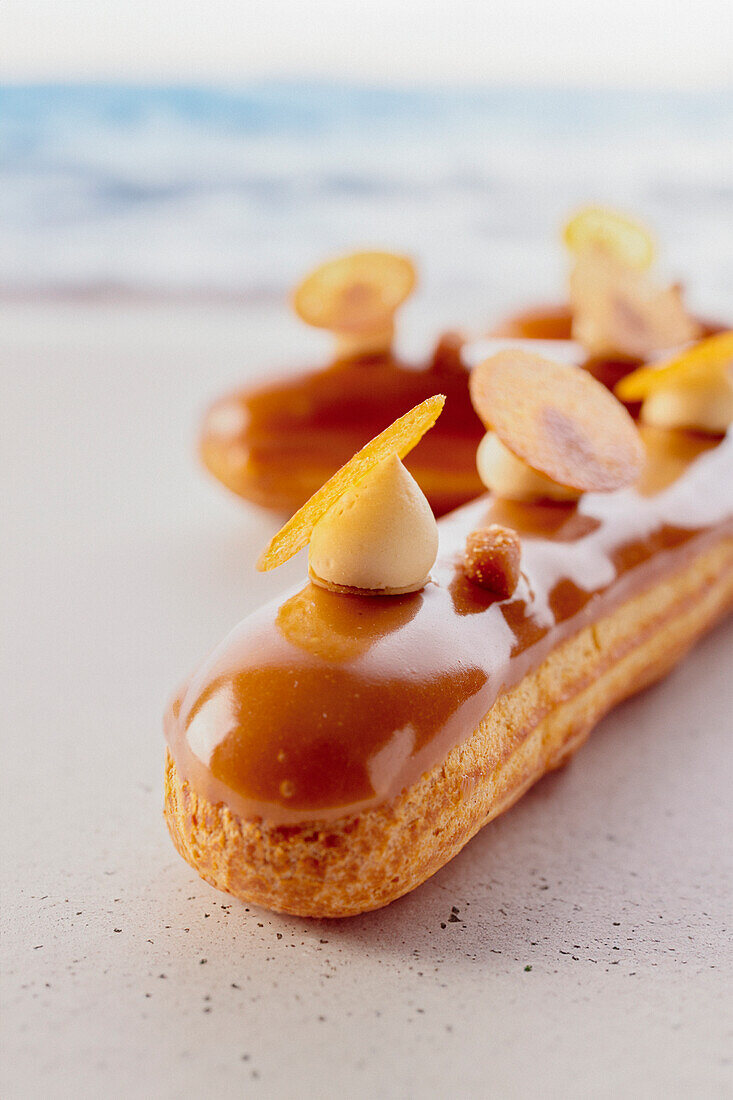 Éclair with caramel glaze and sliced almonds