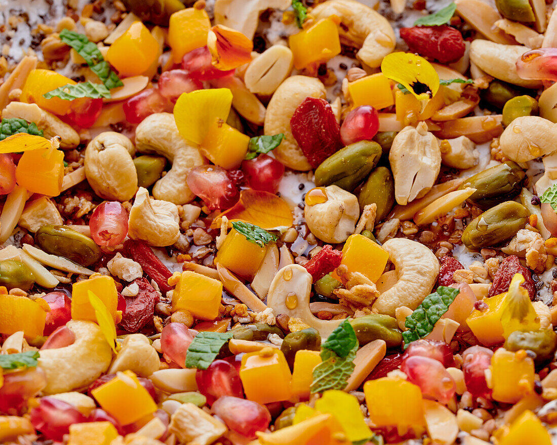 Müsli mit Granatapfel, Mango, Pistazien, Mandeln und Gojibeeren