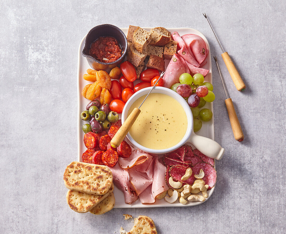 Käsefondue mit Gemüse, Salami, Mortadella und Brot