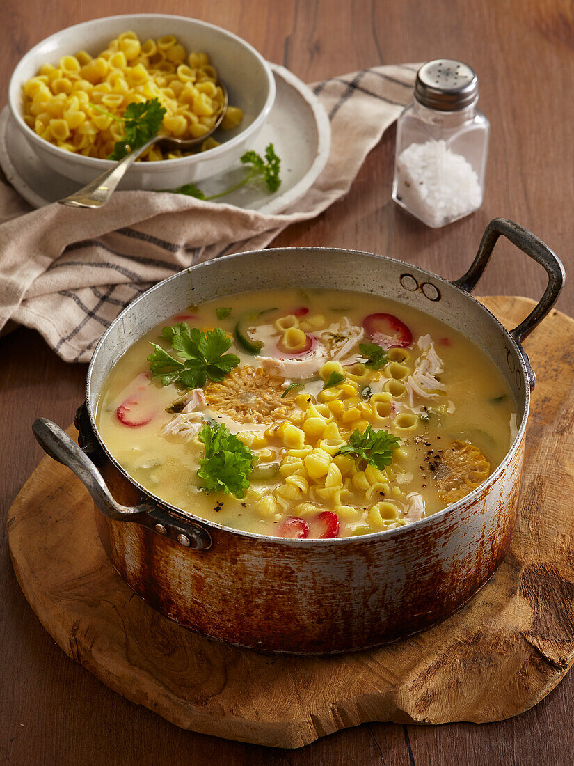 Chicken soup with noodles, sweetcorn and parsley