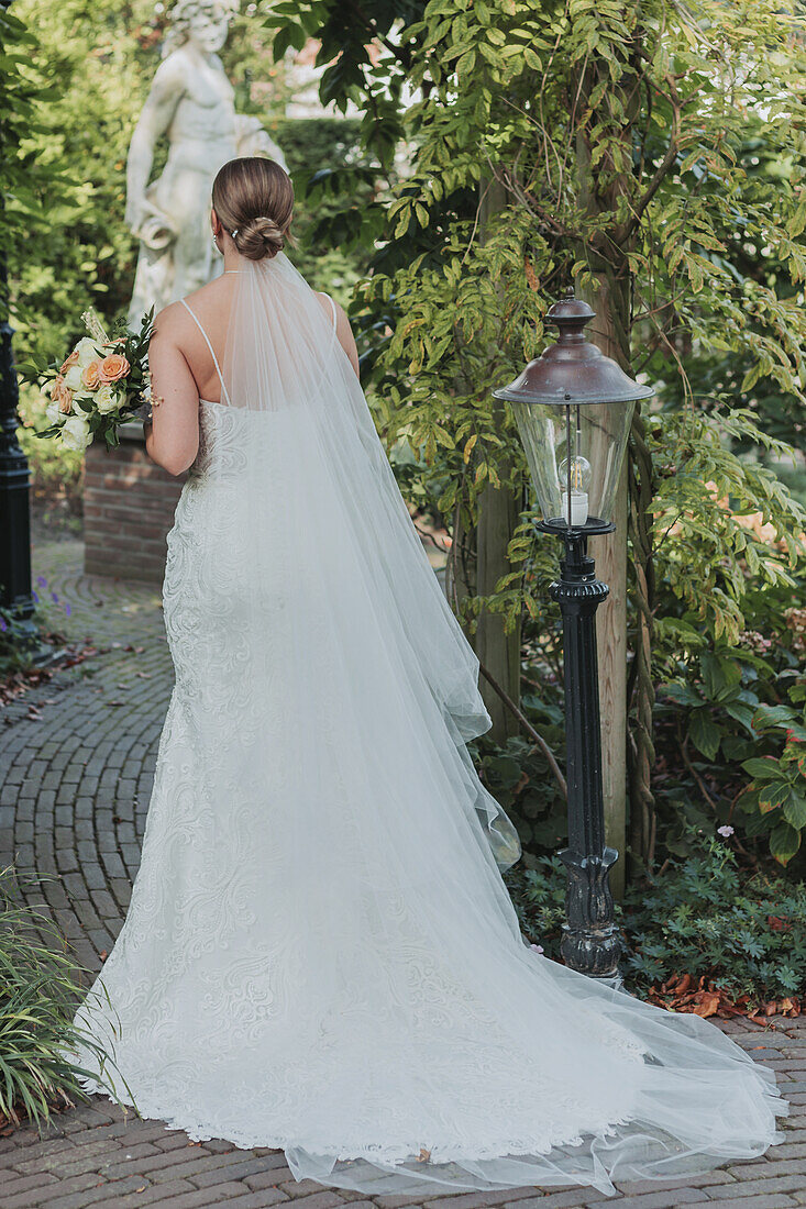 Bride with wedding dress and bouquet in the park