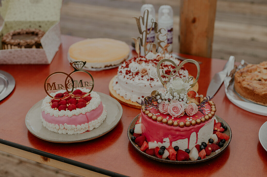 Hochzeitstorten im rustikalen Stil mit Fruchtdekoration auf Holztisch
