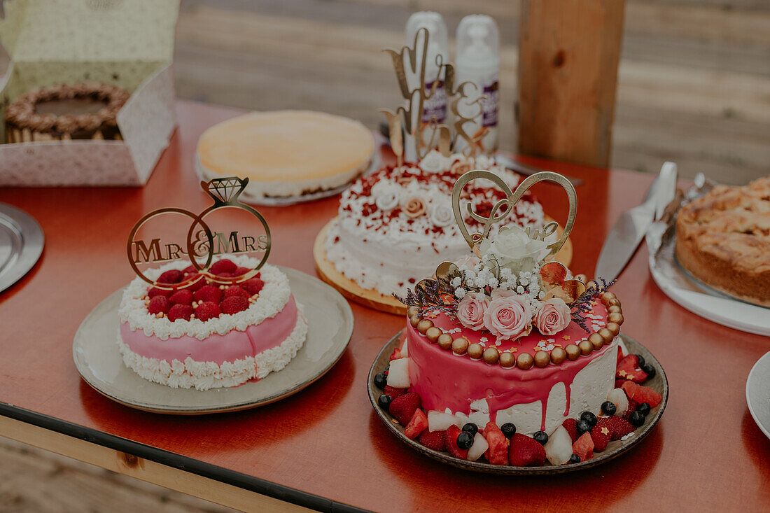 Rustic-style wedding cakes with fruit decoration on wooden table