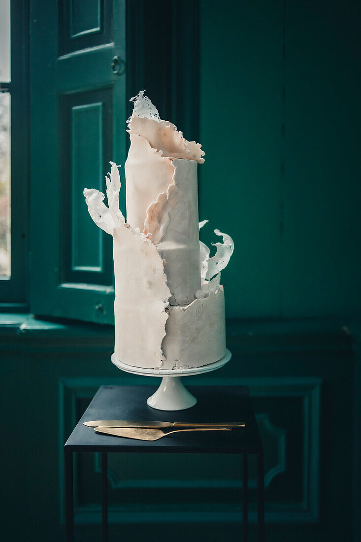 Torte im abstrakten Stil auf schwarzem Tisch vor grüner Tür