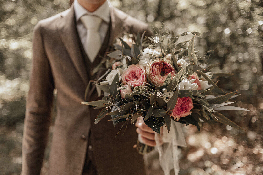 Bridal bouquet in the groom's hand