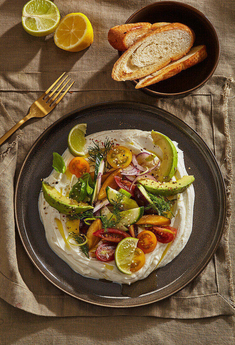 Cremig geschlagener Feta mit Pflaumen, Avocado und Tomaten