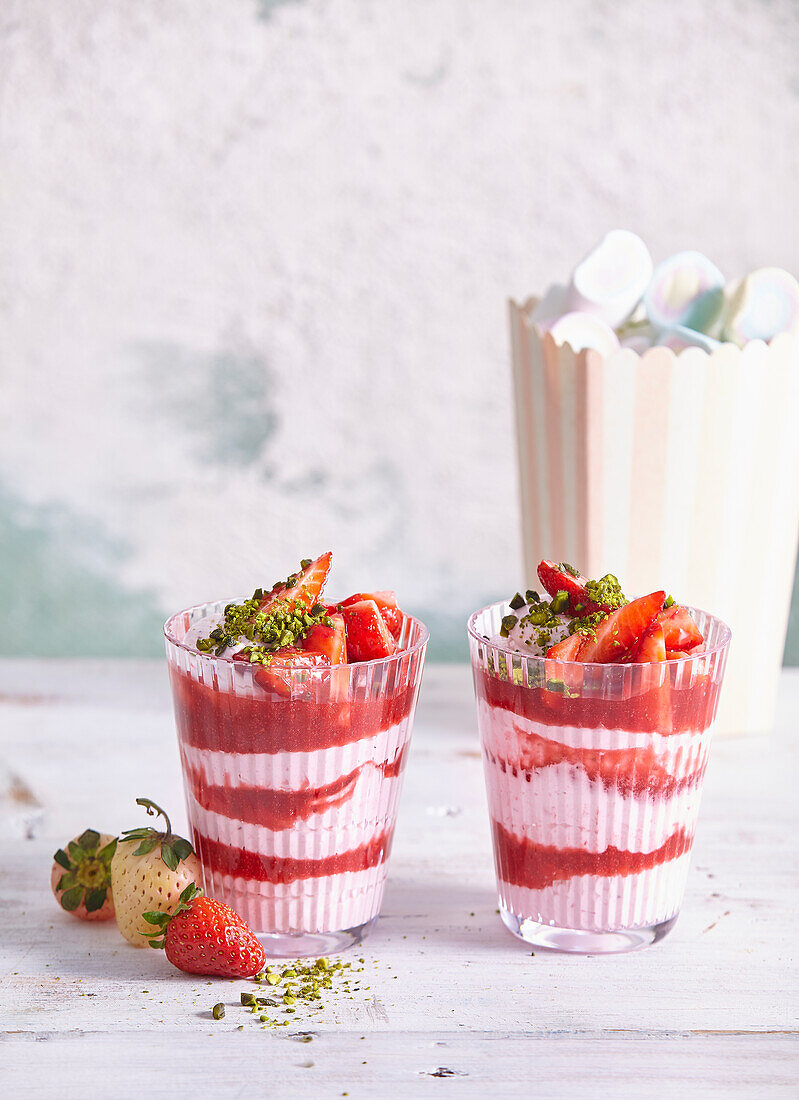 Strawberry cream dessert in a jar with pistachios