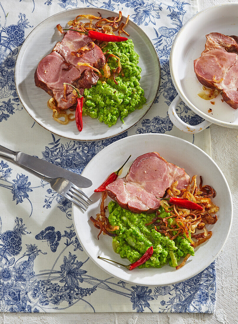 Smoked roast pork with pea puree, fried onions and chilli