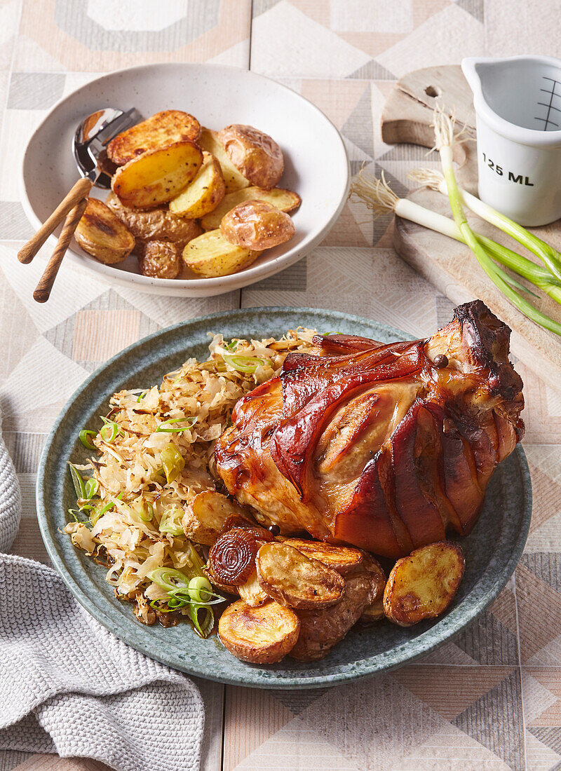 Gebratene Schweinshaxe mit Sauerkraut und Ofenkartoffeln