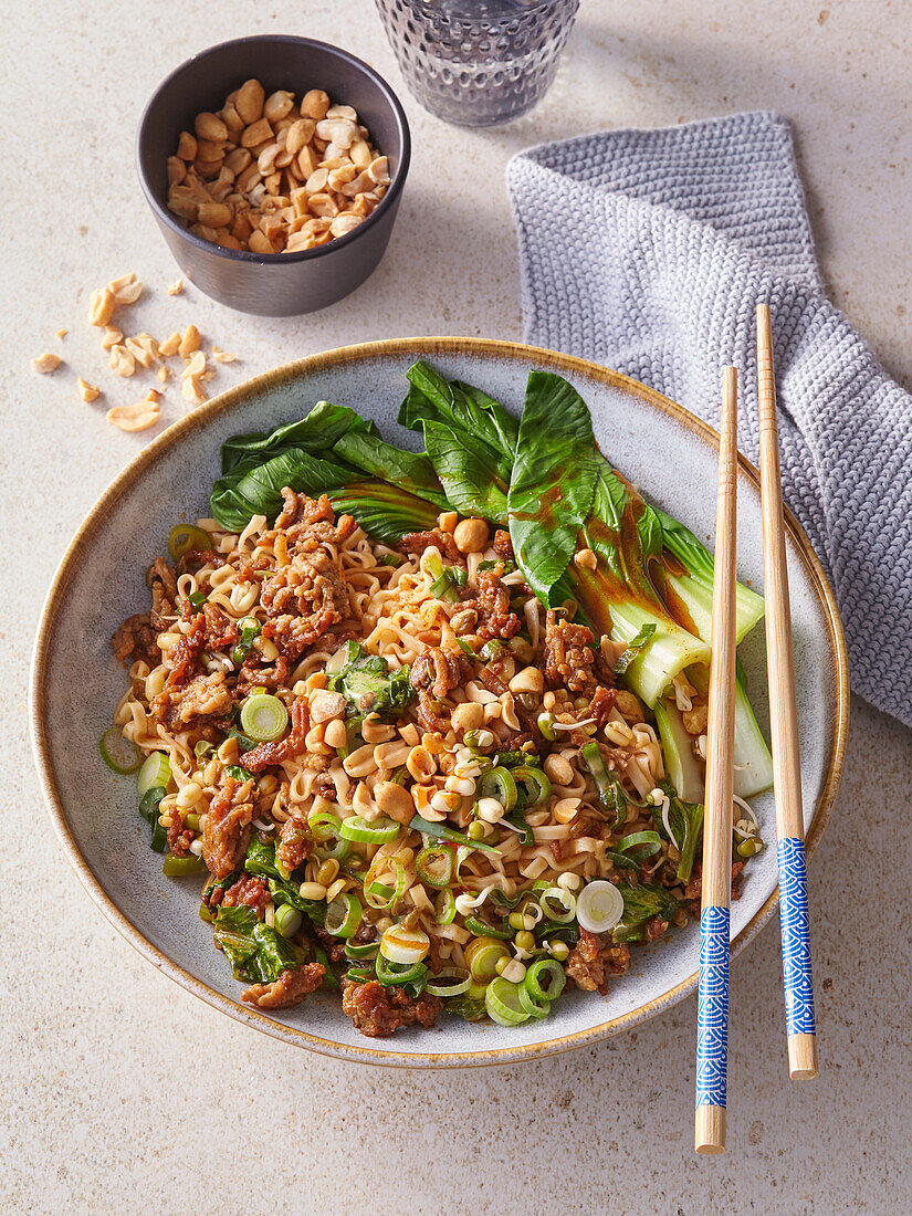 Spicy Asian noodles with minced pork, pak choi and peanuts