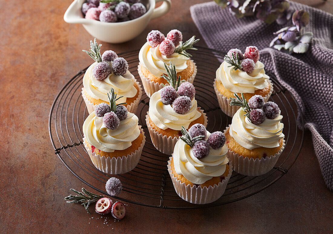 Cupcakes with cream, cranberries and rosemary