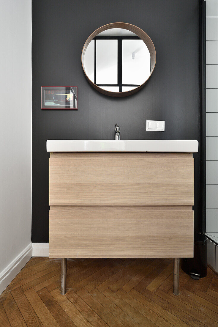 Wooden washbasin with mirror on dark wall