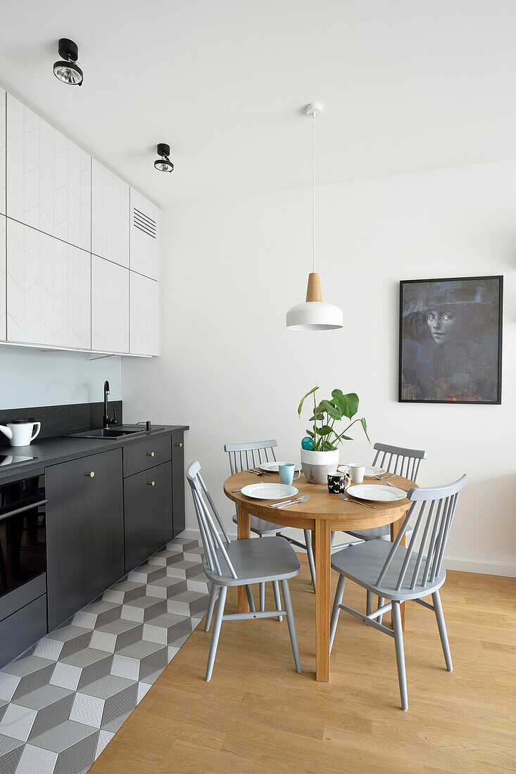 Kitchen with wooden dining table and chairs in grey tones