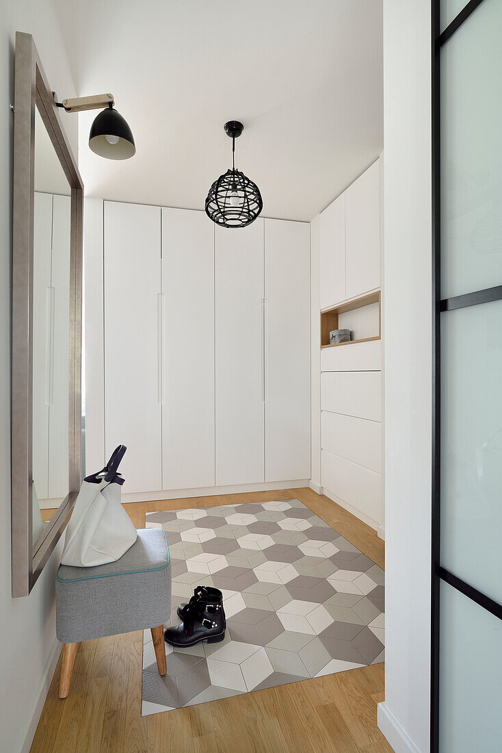 Bright hallway with geometric tiled floor, pendant light and built-in wardrobes