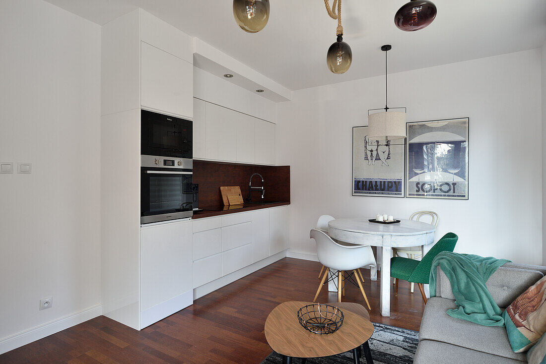 White kitchen, dining and living area with light grey sofa and coffee table