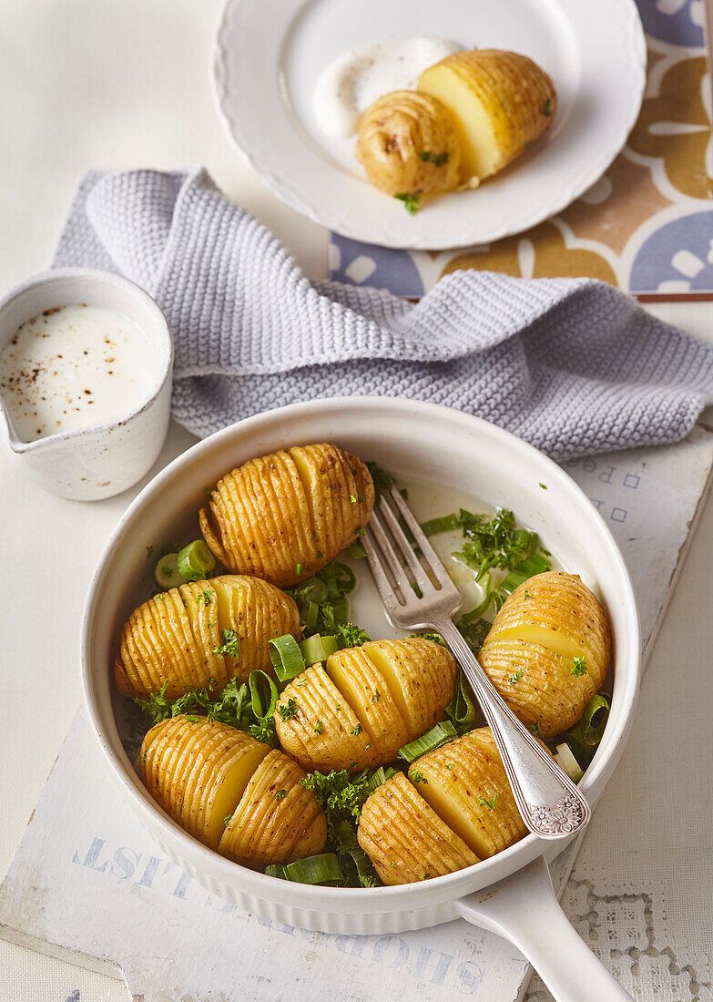 Hasselback potatoes with herbs and spring onions