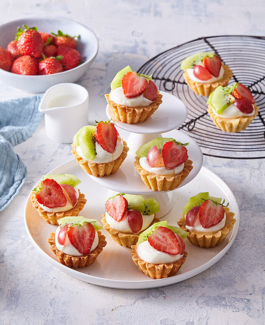 Mini fruit tartlets with cream, kiwi, strawberries and grapes