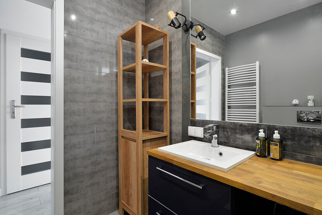 Modern bathroom with wooden details and grey tiles