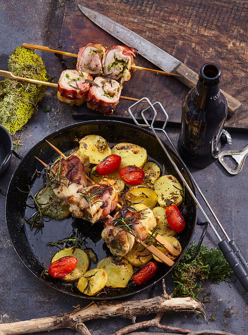 Chicken roulades wrapped in prosciutto on a skewer with rosemary potatoes