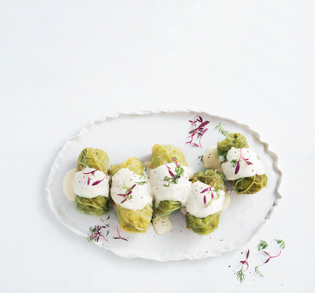 Savoy cabbage rolls with yoghurt sauce and herbs