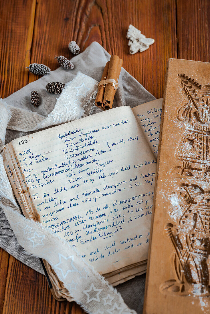 Old cookery book with Christmas recipe, speculaas biscuits and cinnamon sticks