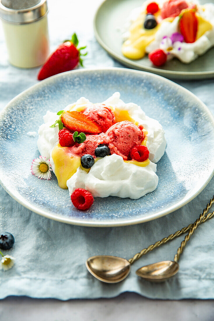 Pavlova with strawberry ice cream, vanilla pudding and berries