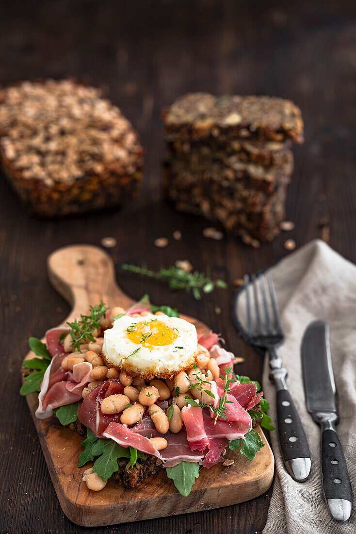 Vollkornbrot mit Schinken, weißen Bohnen und Spiegelei