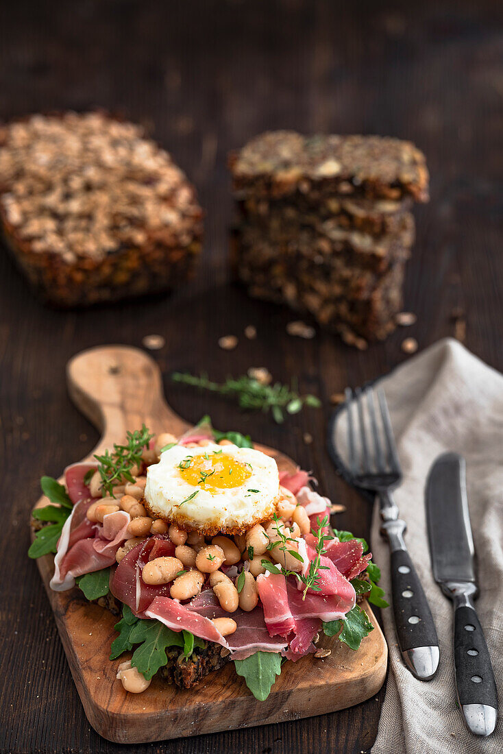 Wholemeal bread with ham, white beans and fried egg