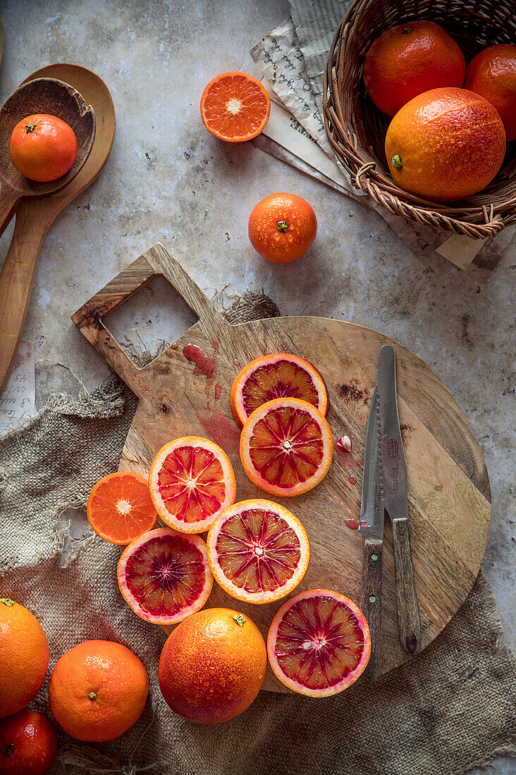 Blood oranges, partially sliced on a wooden board