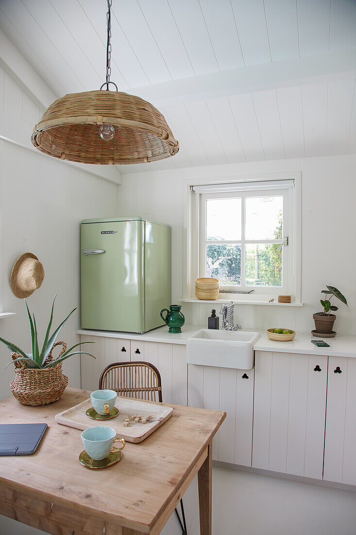 Country-style kitchen with green mini retro fridge and wooden accents