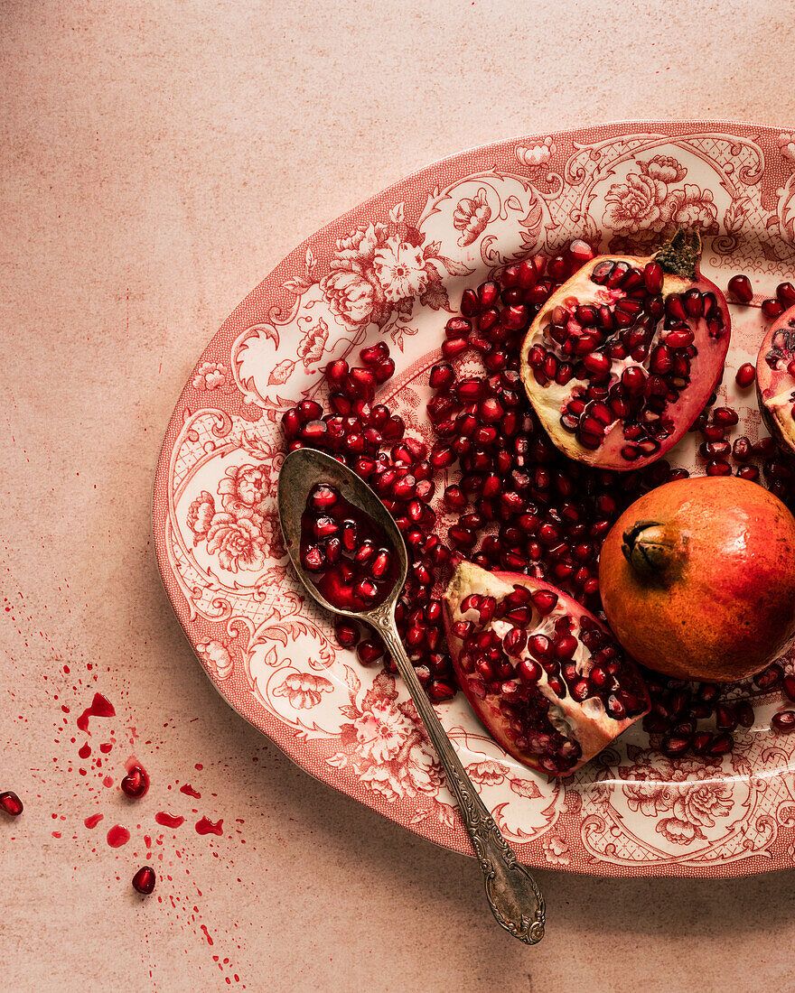 Sliced pomegranate with seeds on an antique plate