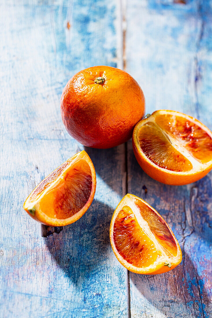 Blood oranges whole and sliced on a wooden base