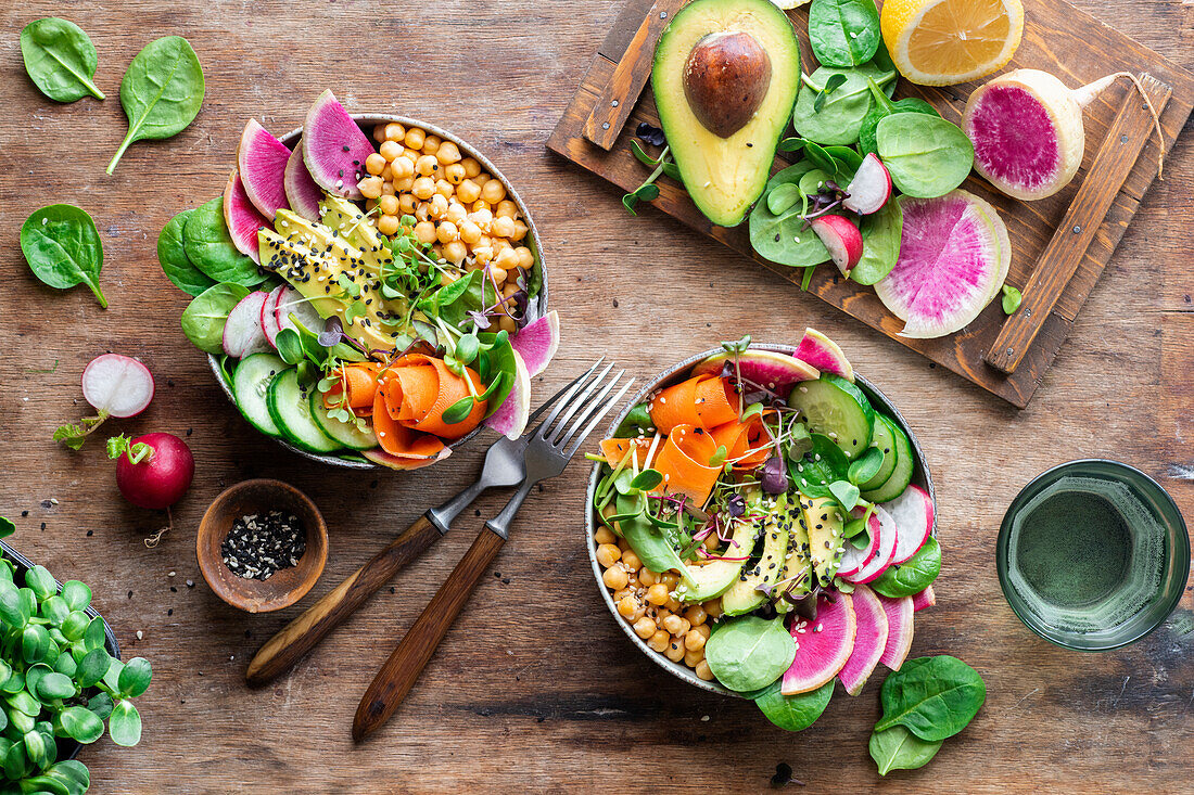 Colourful salad bowls with chickpeas, watermelon radish and avocado
