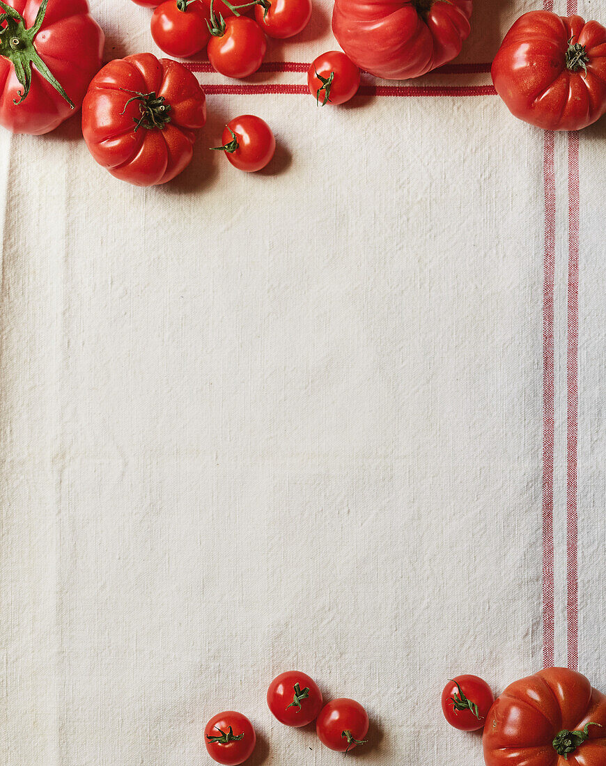 Assorted ripe tomatoes on a tea towel