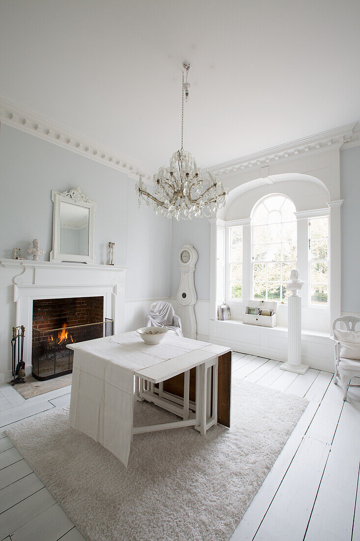 Bright room with fireplace, table and chandelier