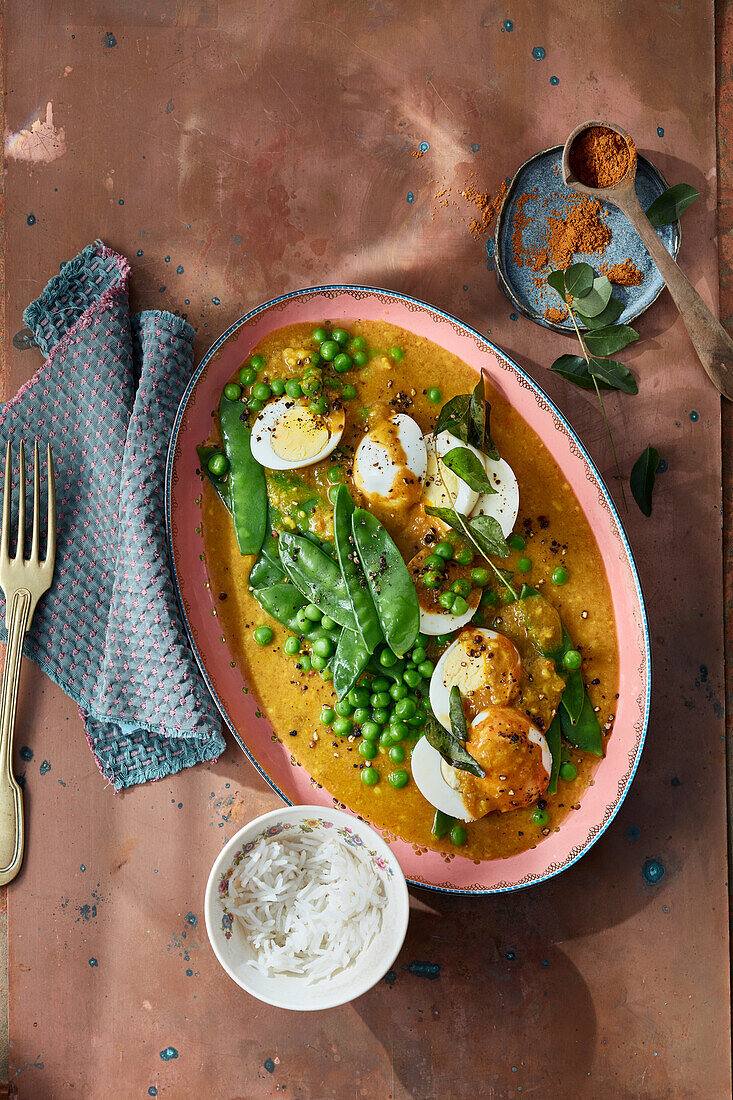 Scharfes Curry mit Ei, Erbsen, Zuckerschoten und Curryblättern