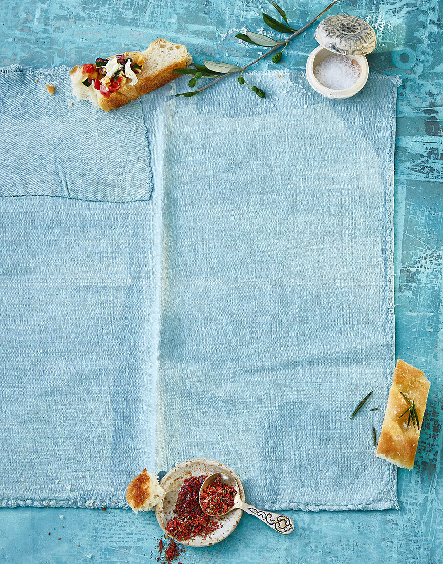 Mediterran-blauer Untergrund mit Focaccia und Gewürzen