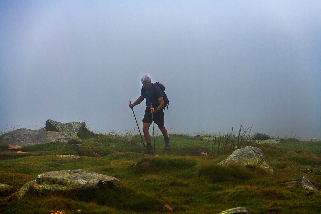 Man walking in hills near mountain