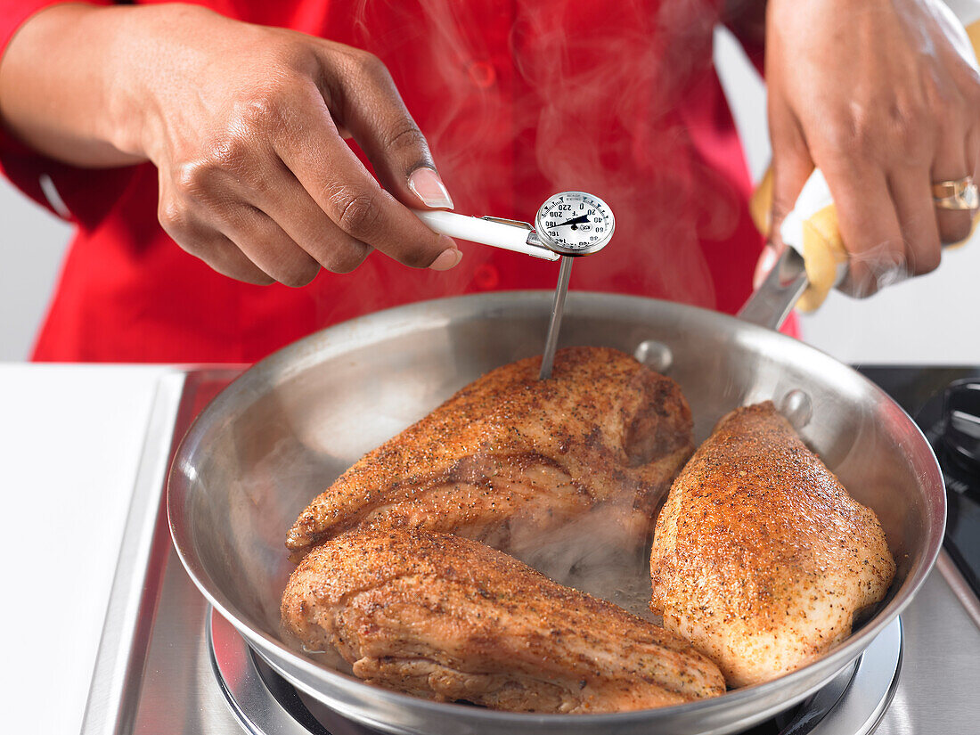 Testing the internal temperature of cooked chicken