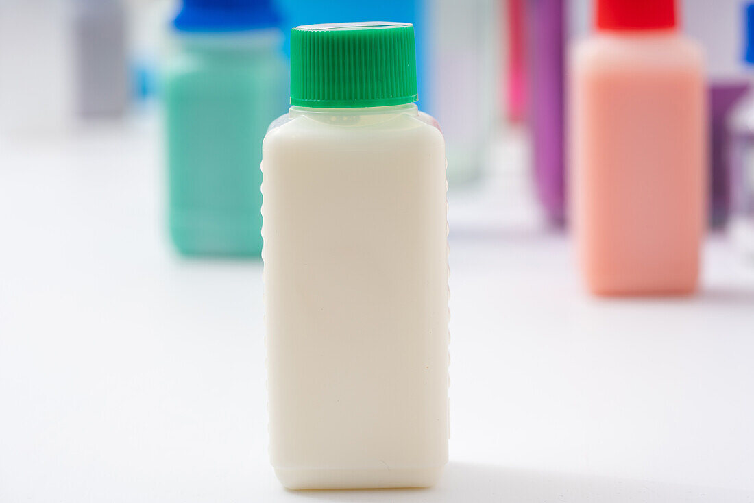 Plastic bottle with white liquid, conceptual image