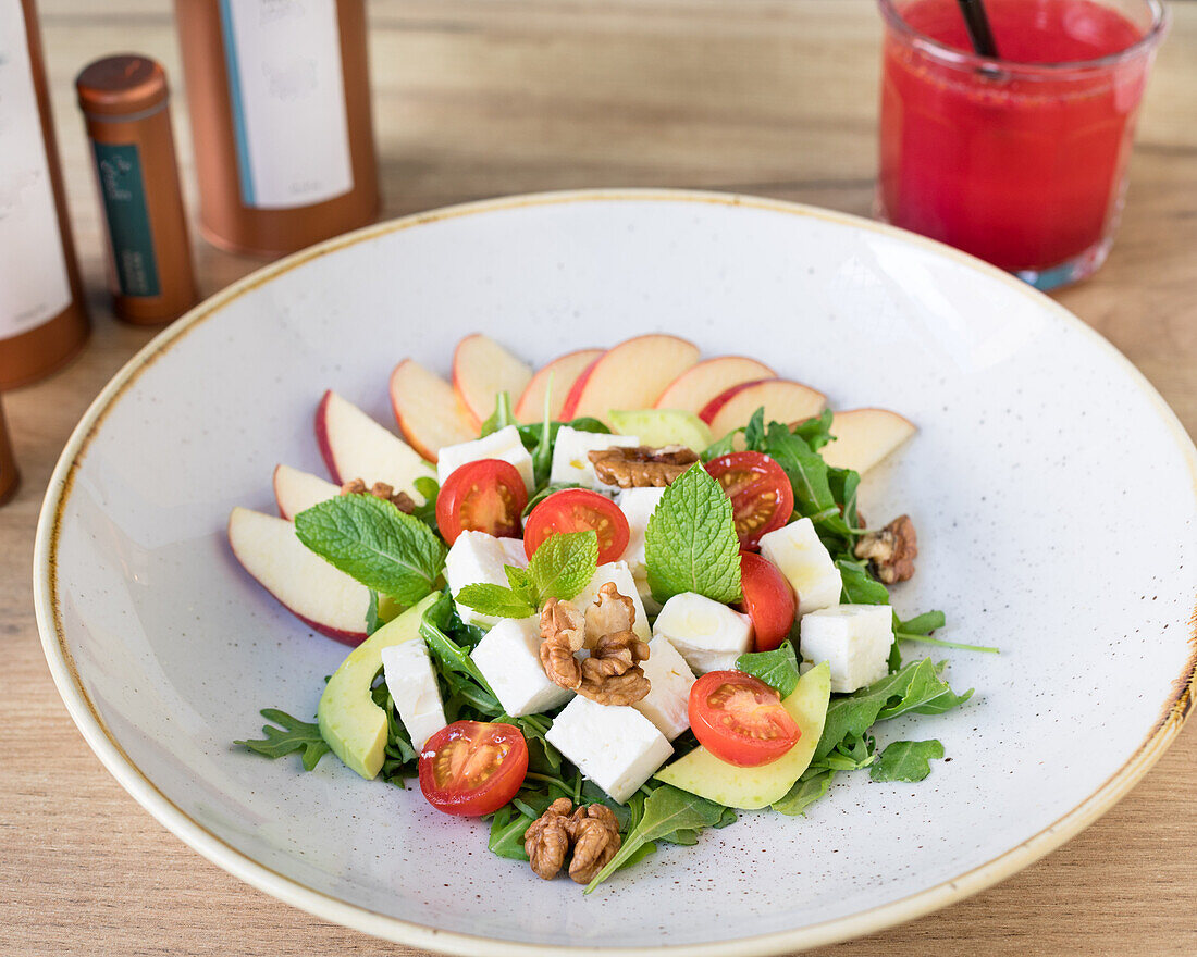 Salad with apple, feta, tomatoes, walnuts and mint