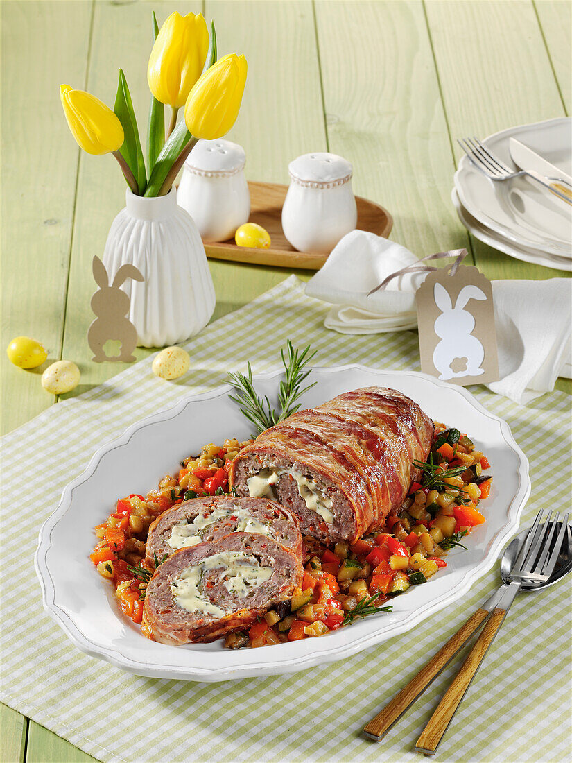 Meatloaf wrapped in ham on ratatouille vegetables