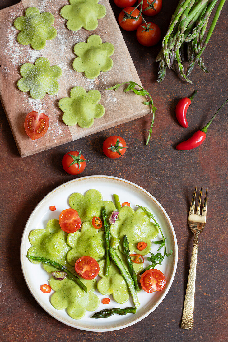 Green ravioli with rocket ricotta filling, asparagus sauce and cherry tomatoes