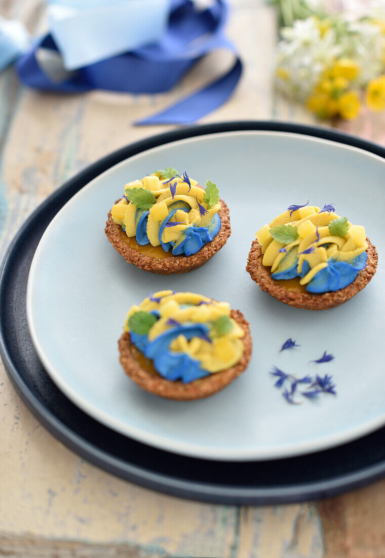 Almond and coconut tartlets with mango and coconut spirulina cream