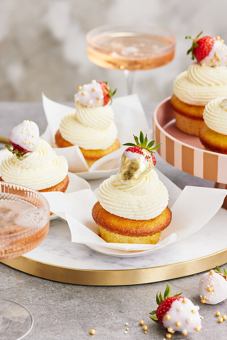 Buttermilk cupcakes with glazed strawberries and gold leaf