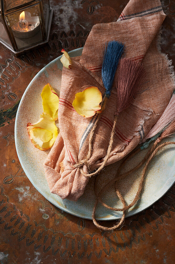 Tischdeko mit Quasten an Jutekordeln, Servietten und Rosenblättern