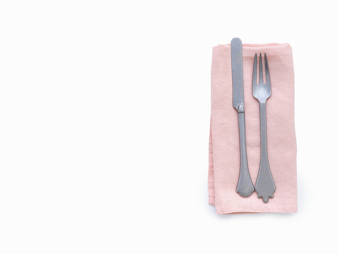 Cutlery on pink cloth napkin