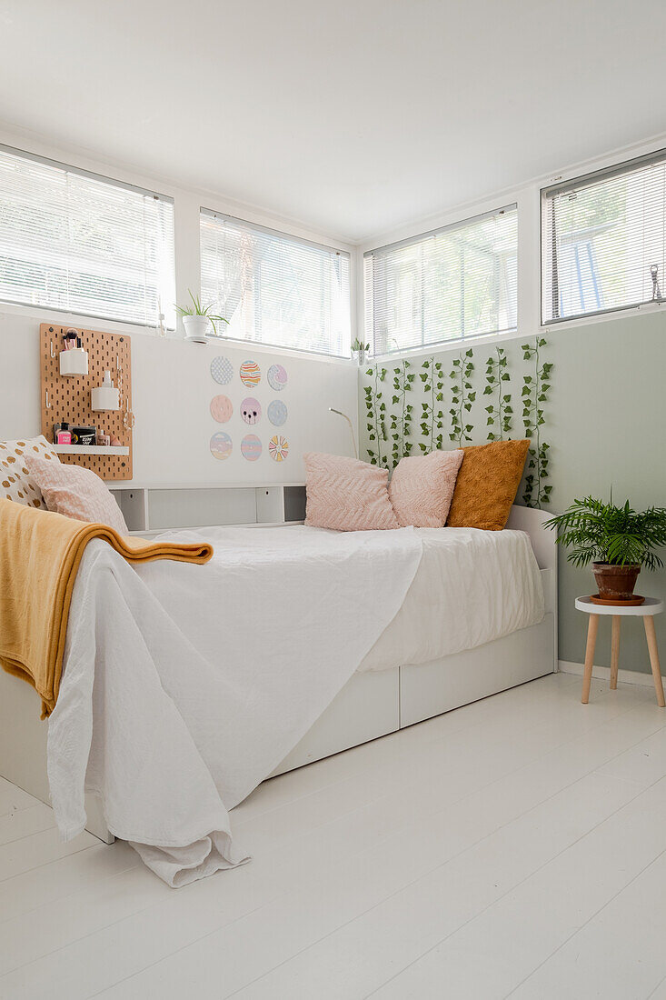 Bedroom with bed, plant decoration and perforated board