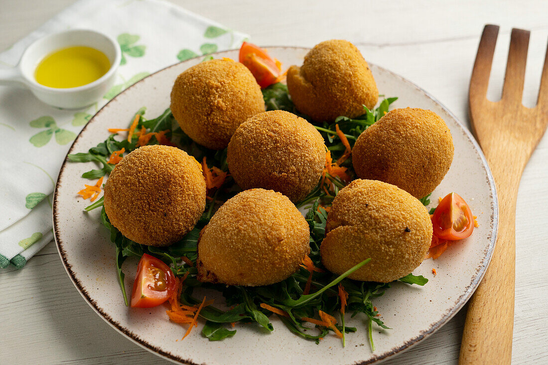 Spanish ham croquettes on rocket salad with tomatoes