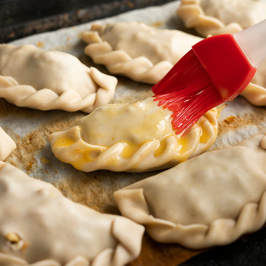 Brush empanadas with egg before baking